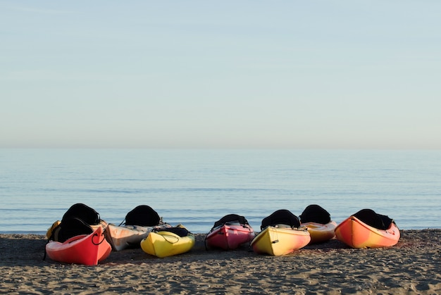 Groupe de canoës sur la plage, mer en arrière-plan