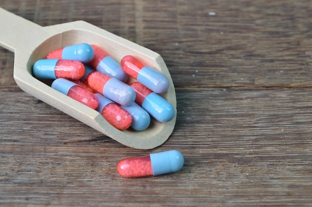 Groupe de capsules de pilules médicales sur table en bois