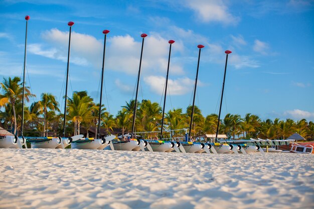 Groupe de catamarans à voiles colorées sur une plage des Caraïbes exotique