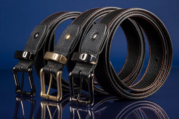 Photo groupe de ceintures en cuir noir sur fond bleu