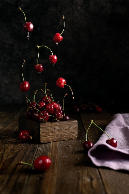 groupe de cerises sur fond de bois foncé ou de baies de cerises fraîches juteuses