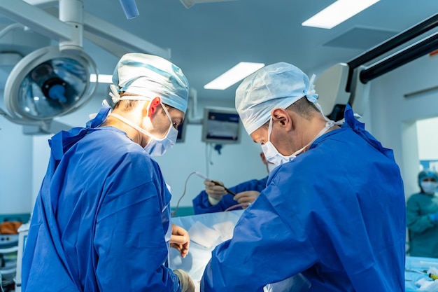 Groupe de chirurgiens opérant dans une chambre d'hôpital moderne