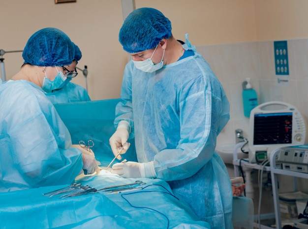 Groupe de chirurgiens en salle d'opération avec équipement de chirurgie.