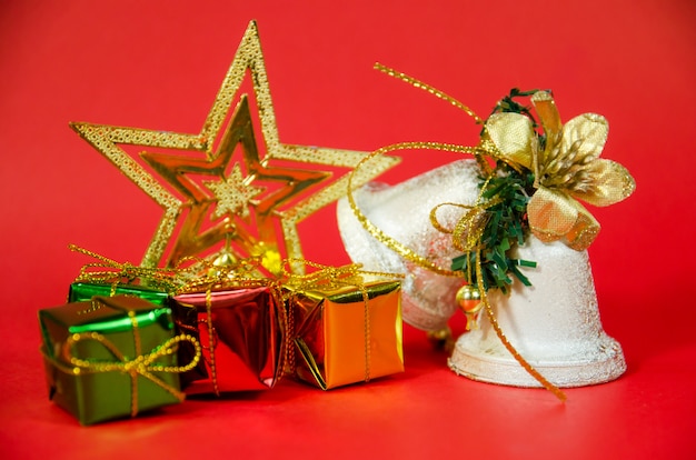 Photo groupe de cloche, cadeau et étoile à noël sur fond rouge