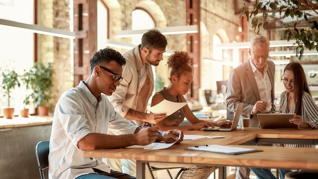 Groupe de collaboration de gens d'affaires concentrés travaillant ensemble et communiquant dans le