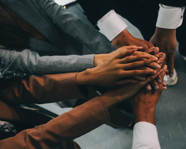 Groupe de collège se toucher les mains pour l'unité groupe à la réussite des affaires