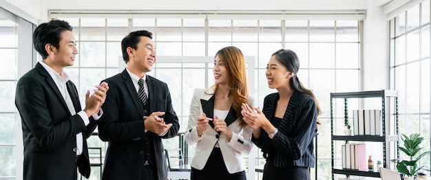 Un groupe de collègues hommes et femmes d'affaires asiatiques souriants et se tenant joyeusement ensemble pour un projet réussi Unité et diversité du poste de directeur exécutif et concept de travail d'équipe des employés