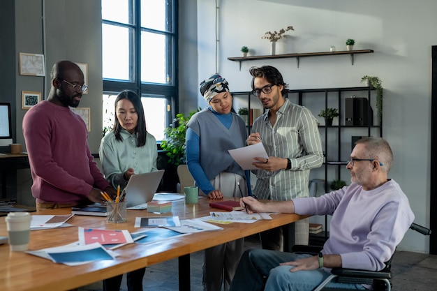 Groupe de collègues interculturels discutant de données et de documents financiers en ligne