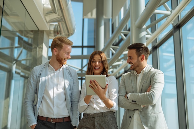 Groupe de collègues travaillant ensemble sur une tablette.