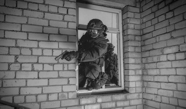 Un groupe de combattants des forces spéciales prend d'assaut le bâtiment par la fenêtre. Séances de formation de l'équipe SWAT