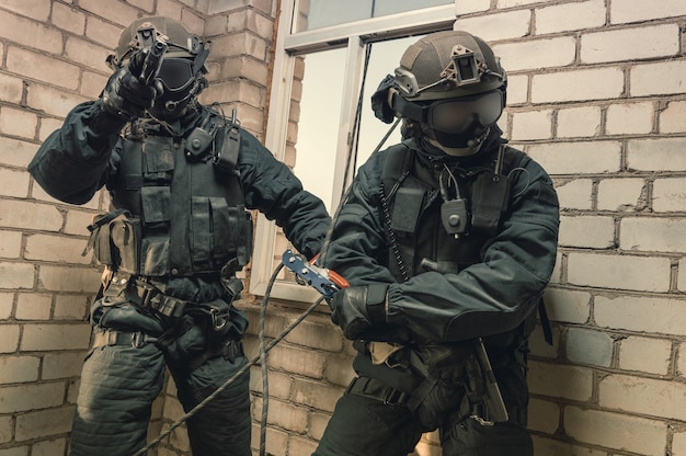 Un groupe de combattants des forces spéciales prend d'assaut le bâtiment par la fenêtre. Séances de formation de l'équipe SWAT