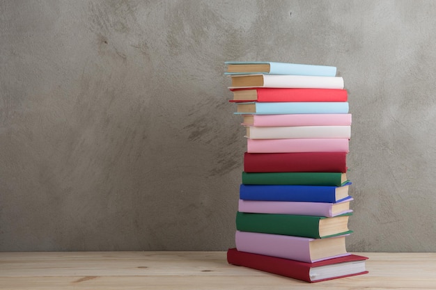 Groupe de concept d'éducation et de lecture de livres colorés sur le tableau noir de mur en béton de table en bois