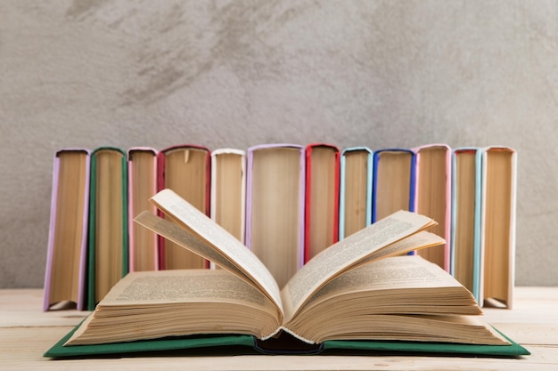 Groupe de concept d'éducation et de lecture de livres colorés sur le tableau noir de mur en béton de table en bois