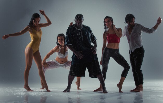 Groupe de danseur dansant sur la scène avec effet pluie