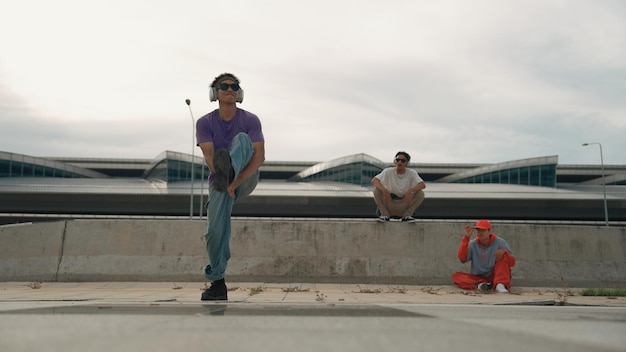 Un groupe de danseurs exécutent une danse de rue avec des amis qui le regardent avec enthousiasme.