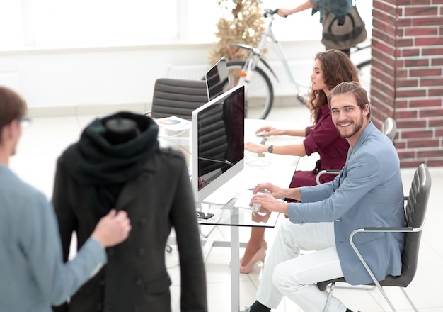 Groupe de designers et de tailleurs travaillant dans le studio photo avec espace de copie