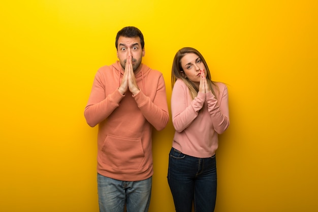 Un Groupe De Deux Personnes Sur Fond Jaune Garde La Paume De La Main.