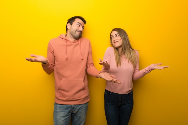 Groupe de deux personnes sur fond jaune, geste sans importance