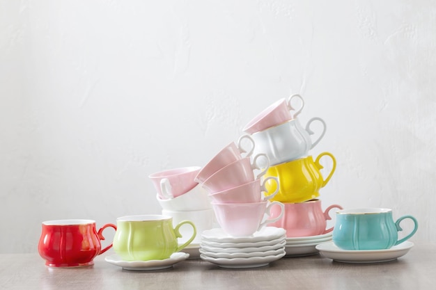 Groupe de différentes tasses sur table en bois sur fond blanc