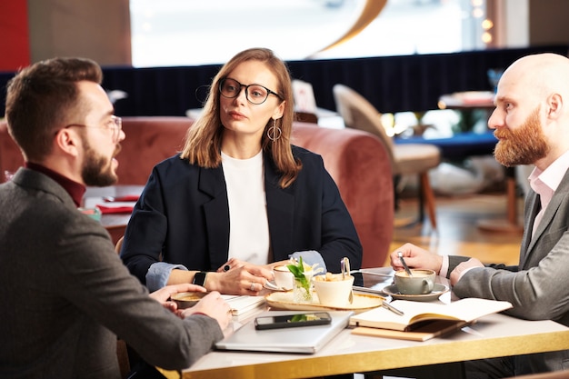 Groupe de dirigeants d'entreprise assis à table dans un restaurant et échanger des idées et des plans