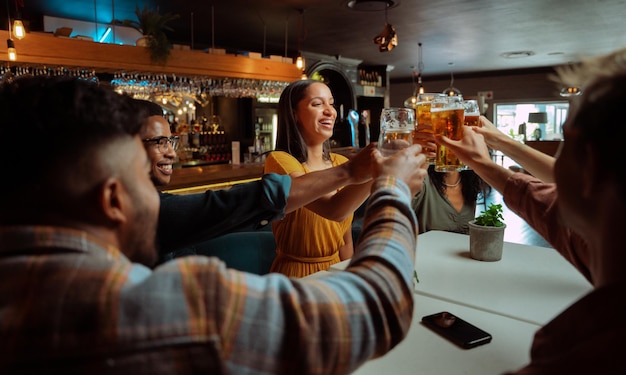 Groupe diversifié d'amis pour des bières portant un toast