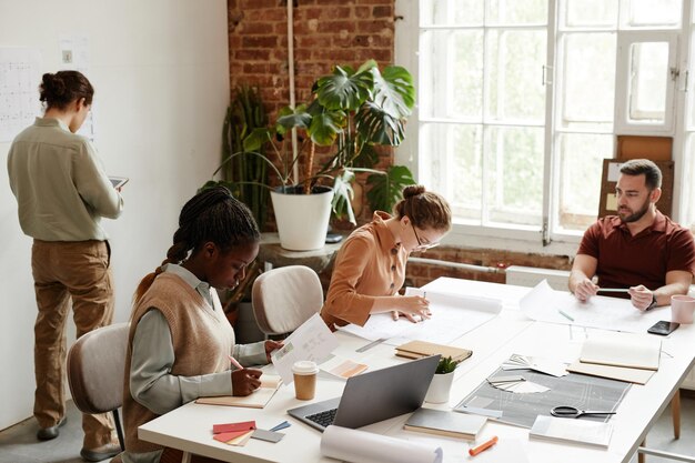 Groupe diversifié d'architectes créatifs travaillant dans un bureau moderne