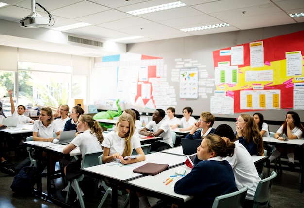 Groupe diversifié d&#39;élèves apprenant dans une salle de classe