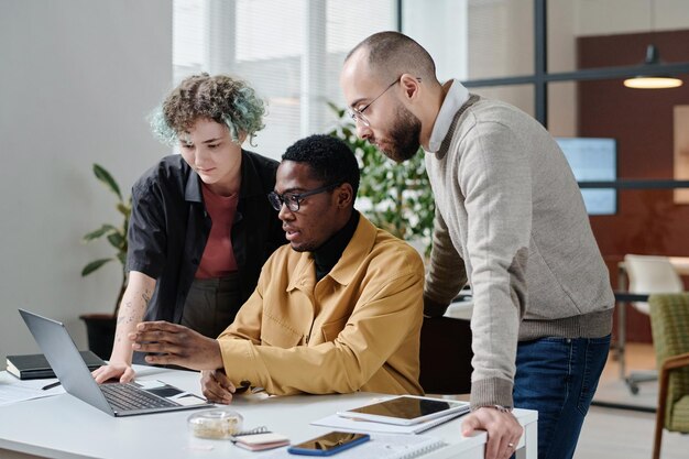 Photo groupe diversifié d'employés de bureau travaillant en équipe sur un projet d'entreprise sur ordinateur