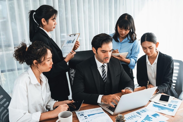 Groupe diversifié d'équipes d'analystes d'affaires analysant le papier de rapport de données financières sur la table de bureau Tableau de bord graphique et graphique par analyse de veille économique pour la planification marketing stratégique Méticuleux