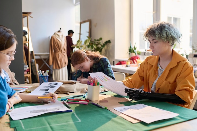 Un groupe diversifié de filles en classe de couture à table