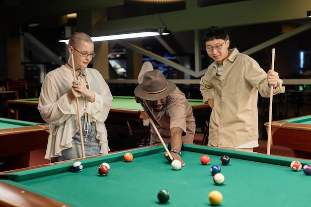 Photo un groupe diversifié de personnes jouant au billard ensemble