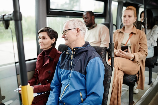 Groupe Diversifié De Personnes Sur Des Sièges Dans Des Bus Publics Se Déplaçant En Ville