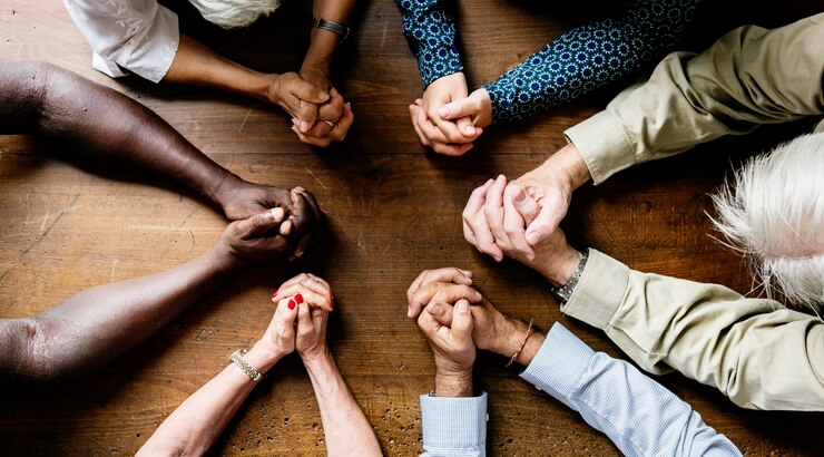 Photo groupe de doigts imbriqués priant ensemble