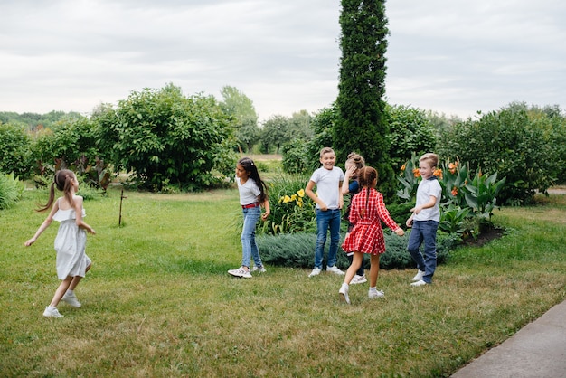 Un groupe d'écoliers court dans le parc en été. Bonheur, mode de vie