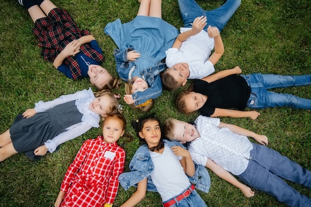 Un groupe d'écoliers s'allonge sur l'herbe en cercle et s'amuse