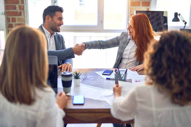 Groupe d'employés d'affaires souriants heureux et confiants Travaillant avec le sourire sur le visage se serrant la main pour un accord au bureau