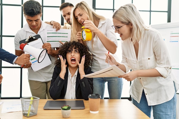 Groupe d'employés d'entreprise criant à un partenaire stressé au bureau