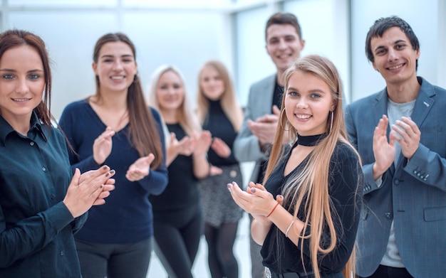 Groupe d'employés heureux debout dans le bureau applaudissant