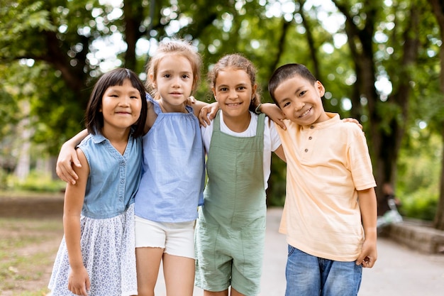 Groupe d'enfants asiatiques et caucasiens s'amusant dans le parc