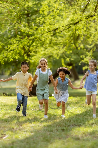 Groupe d'enfants asiatiques et caucasiens s'amusant dans le parc