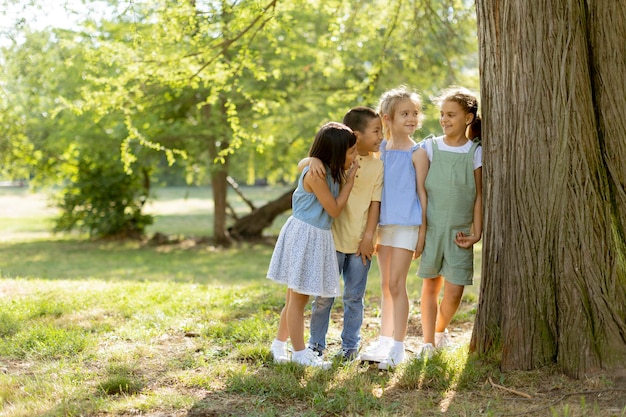 Groupe d'enfants asiatiques et caucasiens s'amusant dans le parc