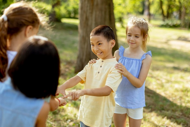 Groupe d'enfants asiatiques et caucasiens s'amusant dans le parc