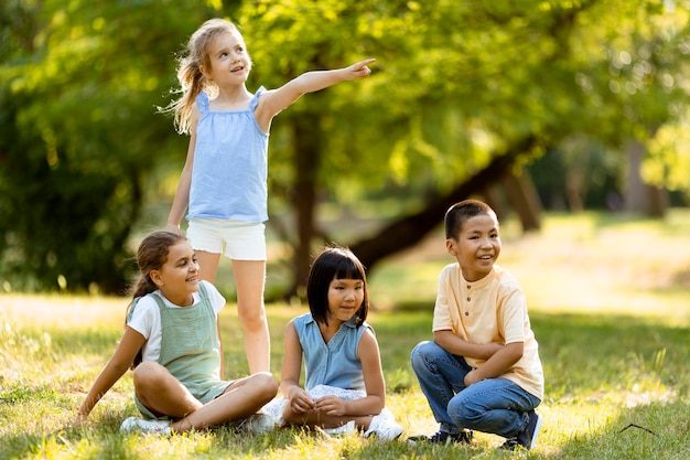 Groupe d'enfants asiatiques et caucasiens s'amusant dans le parc