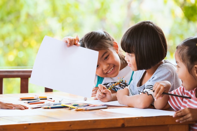 Groupe d&#39;enfants asiatiques dessin et peinture avec crayon ensemble avec plaisir