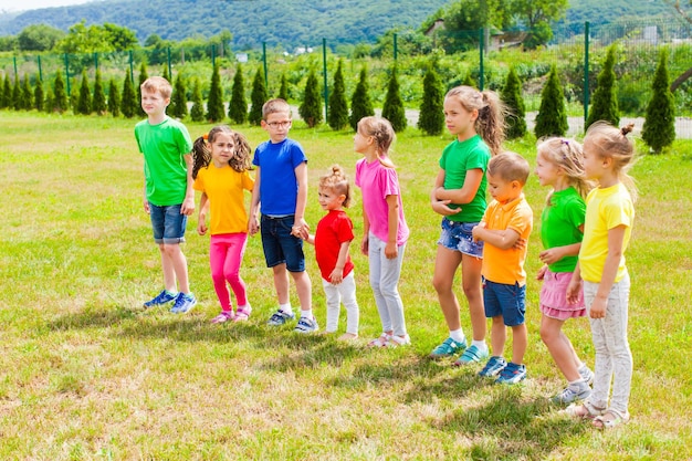 Groupe d'enfants attendant et ennuyeux à l'extérieur. Les enfants sont fatigués