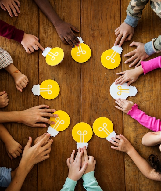 Photo groupe d'enfants brantant et partageant des idées avec une ampoule