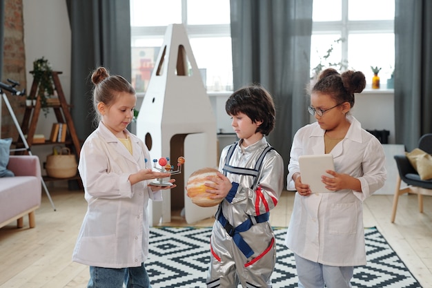 Groupe d'enfants en costumes jouant ensemble dans la chambre