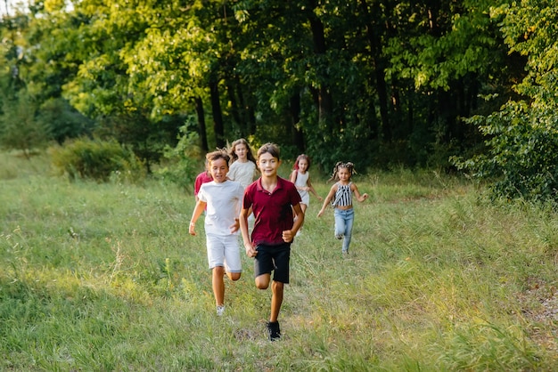 Un groupe d'enfants heureux courir et jouer dans le parc au coucher du soleil