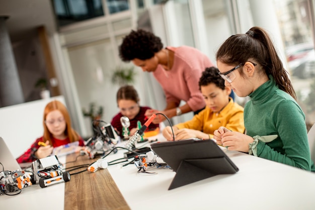 Groupe d'enfants heureux avec leur professeur de sciences afro-américaine