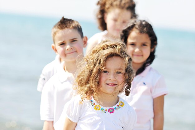 groupe d'enfants heureux sur la plage qui s'amusent et jouent à des jeux